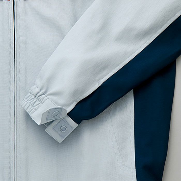 【袖口】<br>袖口と衿のタブはテープスナップ使いで落下を防ぎ、異物としてのボタンの混入を防止します。